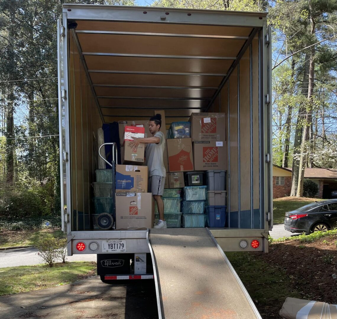 Person loading boxes into moving truck.