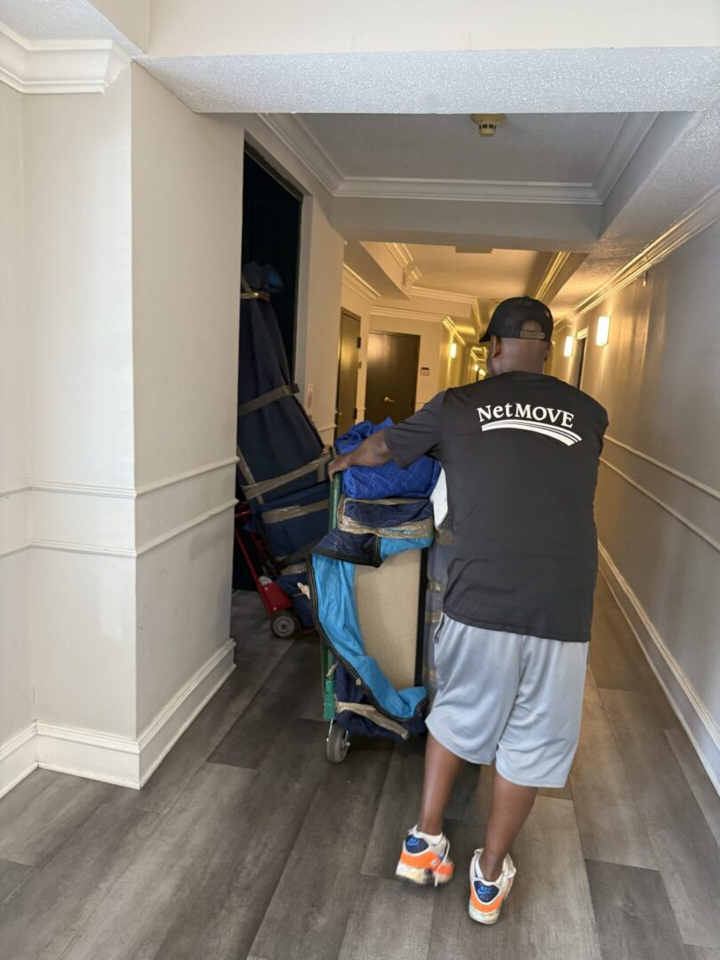 Mover pushing a cart in hallway.