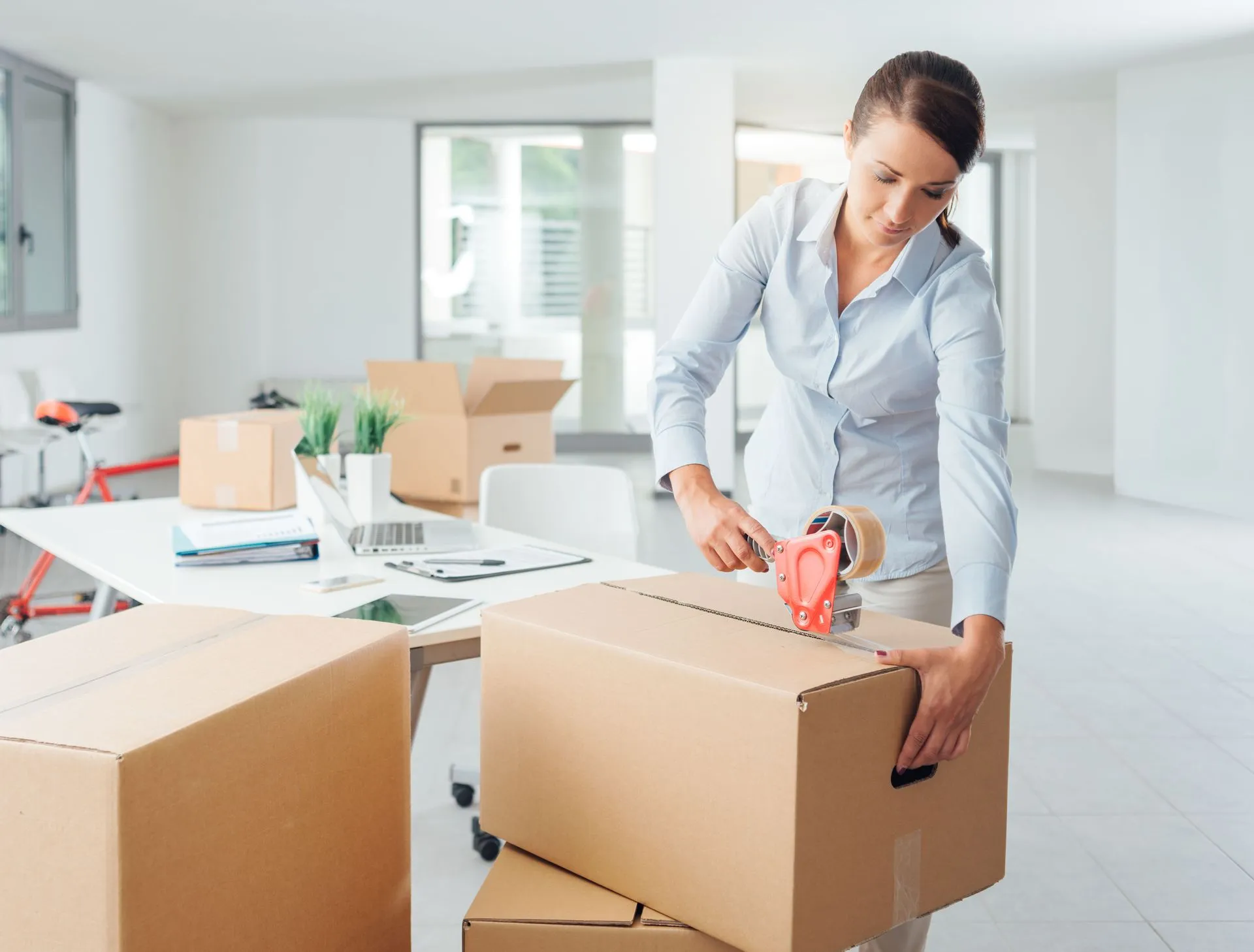 Woman packing boxes in an office.